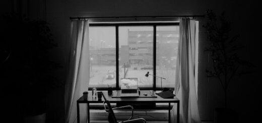 Minimalist home office with laptop, desk lamp, and snowy city view